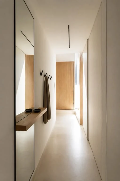 Idée déco couloir moderne avec miroir pleine hauteur et console fine dans un couloir étroit